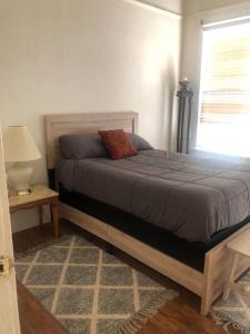 a bedroom with a bed and a lamp and a window at Misha’s Cozy Rare 3brm in Marysville