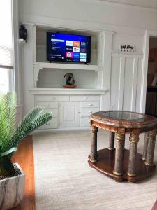 uma sala de estar com uma mesa e uma televisão em Misha’s Cozy Rare 3brm em Marysville