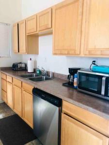 a kitchen with wooden cabinets and a sink and a microwave at Misha’s Cozy Rare 3brm in Marysville +10 photos