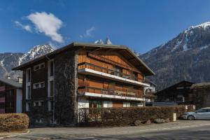 a large apartment building with mountains in the background at Appartement Flégère et Golf - Happy Rentals in Chamonix-Mont-Blanc