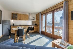 a living room with a blue couch and a kitchen at Appartement Flégère et Golf - Happy Rentals in Chamonix-Mont-Blanc