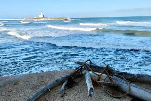 een fiets die op het strand naast de oceaan ligt bij Medieval terraced house in Vieste Vecchia in Vieste
