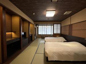 a hotel room with two beds and a television at Mount View Hakone in Hakone