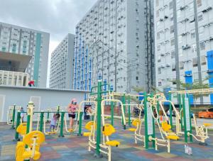 einen Spielplatz mit gelber und grüner Ausrüstung in einer Stadt in der Unterkunft Pandora’s Nest in Manila