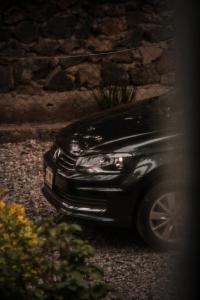 a black car parked next to a stone wall at Hospedaje Casa Teotleco in Tepoztlán