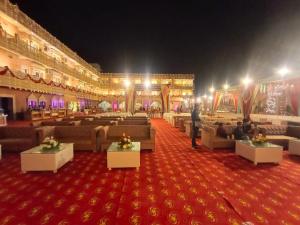 奥拉奇哈Hotel Rajwada palace的一间大房间,在红地毯上设有沙发和桌子