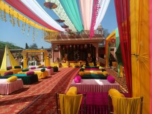 奥拉奇哈Hotel Rajwada palace的宴会厅配有五颜六色的桌椅 更多37张照片