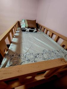 a bed in a room with a wooden frame at D' ALORA Transient House in Daet