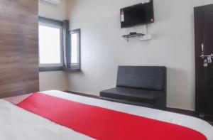 een slaapkamer met een rood-wit bed en een stoel bij Hotel Shanti Heritage, Guna in Guna