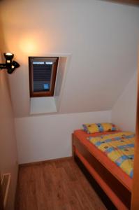 a small bedroom with a bed and a window at Haus Jodokus, Whg Professor Paljass in Kellenhusen