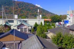 un grupo de edificios con una montaña en el fondo en Aoisora Aoiumi no guest house - Vacation STAY 75101v, en Takamatsu