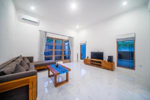 a living room with a couch and a tv at Villa Sayang Sanur 111 in Sanur