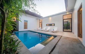 a swimming pool in the backyard of a house at Villa Sayang Sanur 111 in Sanur