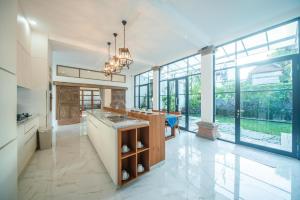 a kitchen with large windows and a large kitchen island at Villa Sayang Sanur 111 in Sanur