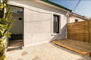 een huis met een houten helling naast een gebouw bij Studio cosy avec terrasse et jardin in Floirac