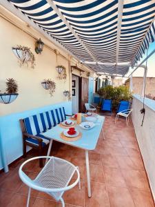 a patio with a blue table and chairs on it at ALMA de TemplarsF Home- Loft with sea view and Terrace in Naples