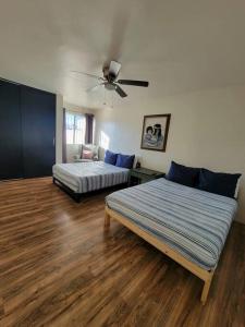 sypialnia z 2 łóżkami i wentylatorem sufitowym w obiekcie Tu Casa de Familia w mieście Tijuana