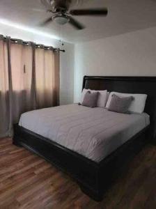 a bedroom with a large bed with a ceiling fan at Tu Casa de Familia in Tijuana