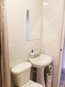 Baño blanco con aseo y lavamanos en Tu Casa de Familia en Tijuana