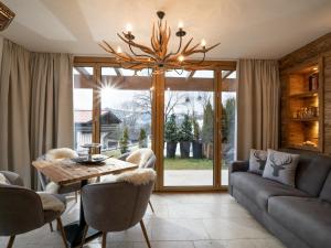 a living room with a couch and a chandelier at Alpine Lodge Brixen in Brixen im Thale