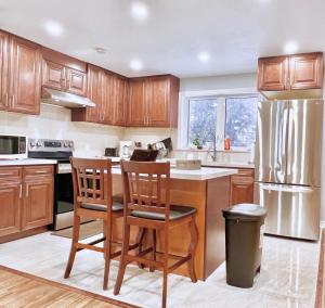 a kitchen with wooden cabinets and a stainless steel refrigerator at Spacious Rooms with Bath Near Wonderland & Vaughan Mills Mall in Vaughan
