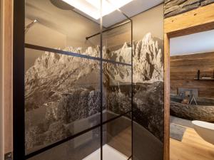 a bathroom with a mountain mural on the wall at Alpine Lodge Brixen in Brixen im Thale +48 photos