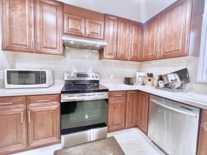 a kitchen with wooden cabinets and a stove and microwave at Luxurious Renovated Rooms in Central Vaughan in Vaughan
