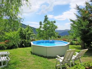 een hot tub in de tuin met 2 ligstoelen bij Cottage Il Poderino in Londa