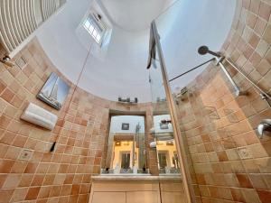 een grote badkamer met een wenteltrap en een douche bij ALMA de TemplarsF Home- Loft with sea view and Terrace in Napels
