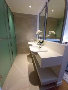a bathroom with two sinks and a mirror at Lovely Studio in Novotel Suites, Metro Manila in Manila