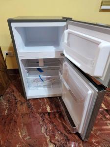 an empty refrigerator with its door open in a room at D' ALORA Transient House in Daet