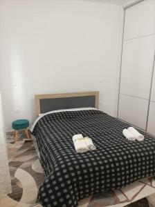 a bedroom with a black and white bed with three towels at Εirene room in Chalkida