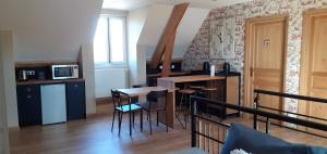 a kitchen with a table and chairs in a room at Au P'tit Versailles in Châtillon-sur-Seine