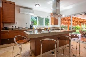 a kitchen with a island with bar stools at Villa Golf Holiday Private Pool, Barbecue, Family Friendly, Golf Course in Playa del Carmen
