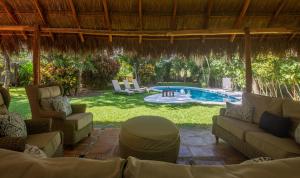 a patio with couches and a pool in a yard at Villa Golf Holiday Private Pool, Barbecue, Family Friendly, Golf Course in Playa del Carmen