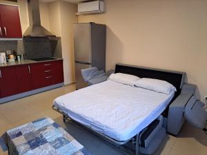 Habitación con 1 cama en una cocina con nevera. en Apartamentos Irina, en Gandía