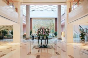 a lobby with a table with flowers in it at Marco Polo Jin Jiang in Jinjiang