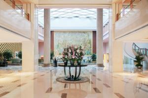 um lobby com uma mesa com flores em Marco Polo Jin Jiang em Jinjiang