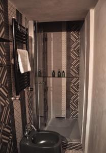 y baño con ducha y lavabo negro. en Appartamento a Villa Rosa en Compiobbi