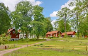uma quinta com casas vermelhas e uma estrada de terra em Nice Home In Skvde With Kitchen em Skövde