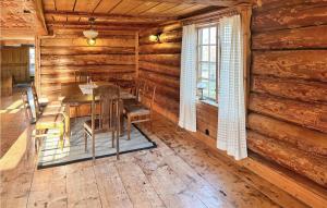 Nice Home In Skvde With Kitchen في سكوفدي: غرفة طعام في كابينة خشب مع طاولة وكراسي