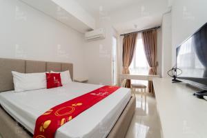 Habitación de hotel con cama y TV en RedLiving Apartemen Barsa City by Ciputra - WM Property, en Yogyakarta