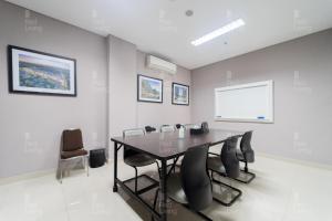 a dining room with a table and chairs at RedLiving Apartemen Barsa City by Ciputra - WM Property in Yogyakarta +32 photos