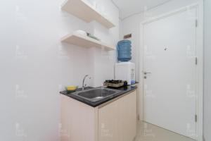 a small kitchen with a sink in a room at RedLiving Apartemen Barsa City by Ciputra - WM Property in Yogyakarta