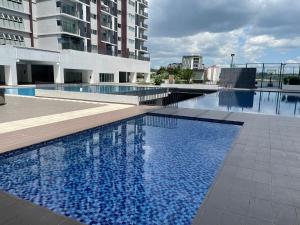 a large swimming pool with blue water in a building at Premium Service Appartment in Seri Kembangan +9 photos