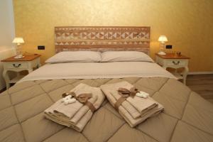 een bed met handdoeken en knuffels erop bij Civico 26 in Rimini
