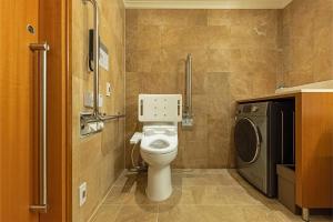 a bathroom with a toilet and a washing machine at Hotel Metropolitan Premier Taipei in Taipei