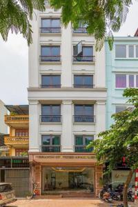 a tall white building with a store in front of it at Granda Quan Hoa Apartment in Hanoi