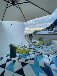 a balcony with a table and chairs and an umbrella at La Pigolina in Positano