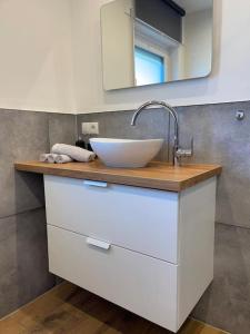 y baño con lavabo blanco y espejo. en Südschleife Appartements - App. 2 - WLAN - Direkt am Ring, en Reimerath
